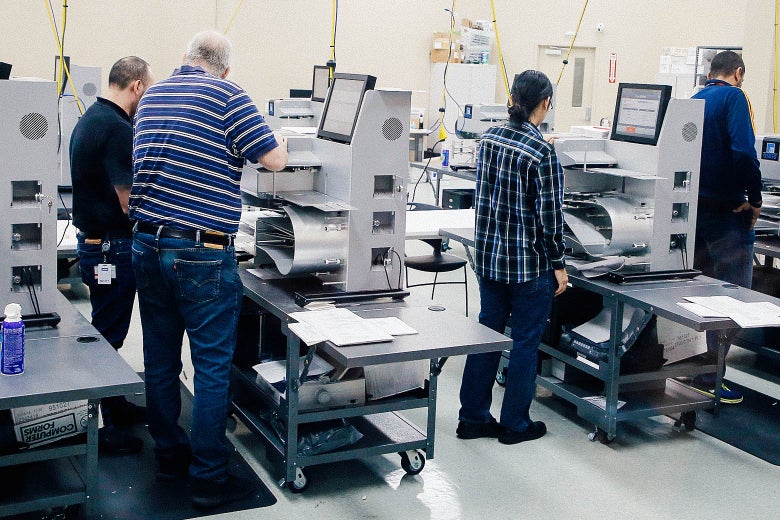 Elections officials work at machines.